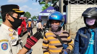 Petugas saat mengecek SIKM warga yang hendak masuk wilayah Jakarta, di check point Pasar Rebo, Rabu (3/6/2020). (Suara.com/Bagaskara Isdiansyah)