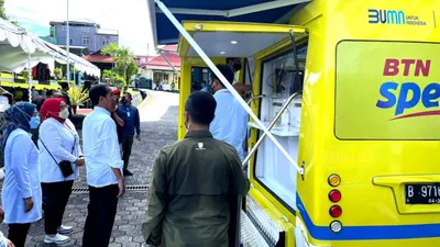 Presiden Jokowi didampingi Menteri Ketenagakerjaan Ida Fauziyah menyaksikan peserta penerima Bantuan Subsidi Upah (BSU) melakukan penarikan dana melalui ATM pada Mobil Kas Keliling (MKK) Bank BTN di Ternate, Maluku Utara, Selasa (27/9/2022).