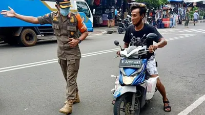 Salah satu warga yang mengendarai sepeda motor di Jalan Lorong 104 Permai, Koja tidak memakai masker dan dirazia Satpol PP/dok: utara.jakarta.go.i