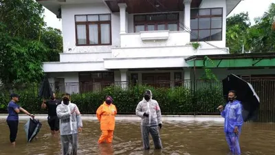 Petugas memantau banjir yang terjadi di jalan di depan rumah Kapolri Listyo Sigit Prabowo di Kelurahan Bangka, Kecamatan Mampang Prapatan, Jakarta Selatan, Kamis (18/2) siang.