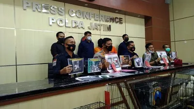 Personel Ditreskrimsus Polda Jatim dan BBKSDA menunjukan tersangka beserta sejumlah satwa langka yang diamankan saat press release, Rabu (17/2/2021).