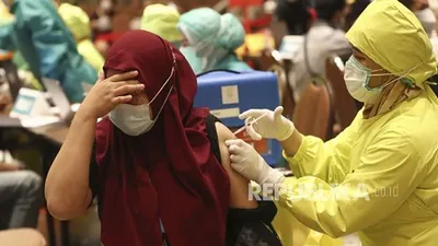 Seorang wanita menerima suntikan vaksin COVID-19 Sinovac saat vaksinasi massal untuk pedagang dan pekerja di sebuah pusat perbelanjaan di Tangerang, Indonesia, Senin, 1 Maret 2021.  Foto: AP/Tatan Syuflana