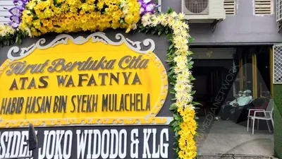 Karangan bunga ucapan duka cita dari Presiden Joko Widodo terpampang di depan rumah duka Habib Hasan Mulachela di kawasan Pasarkliwon, Solo, Jumat (12/3/2021). (Ayojakarta/Budi Cahyono)