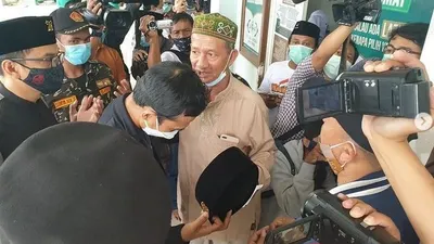 Ustadz Abdul Shomad mencopot kopiah untuk didoakan oleh KH Agoes Ali Masyhuri, pengasuh pondok pesantren Bumi Sholawat, Sidoarjo (baju coklat)/ustadzabdulsomad_official
