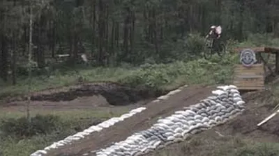 Pesepeda downhill terbang dari lintasan north shore di track baru Galunggung Bike Park objek wisata alam Gunung Galunggung, Kabupaten Tasikmalaya, Minggu (7/3/2021). (Ayotasik.com/Heru Rukanda)