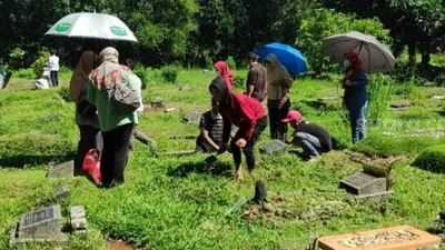 Padatnya para peziarah ke makam dimanfaatkan para pembersih makam untuk mengais rezeki. (dok Suara.com)
