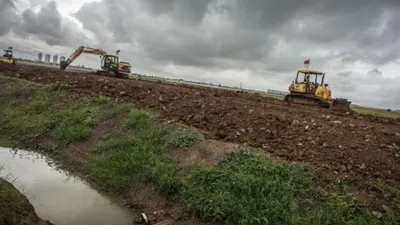 Pekerja dibantu alat berat menyiapkan lahan untuk Tempat Pemakaman Umum atau TPU Rorotan, di Jakarta Utara, Selasa (5/1/2021). [ANTARA FOTO/Aprillio Akbar]