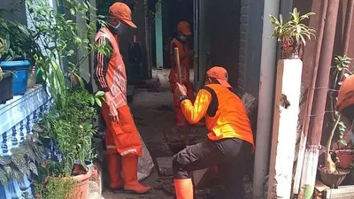 Petugas PPSU Kelurahan Makasar saat membersihkan saluran air/dok: timur.jakarta.go.id