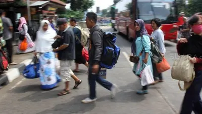 Pemudik saat tiba di Terminal Bus Kampung Rambutan, Jakarta, Sabtu (8/6). [Suara.com/Arief Hermawan P]
