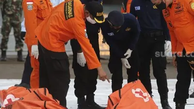 Petugas gabungan memeriksa kantung jenazah berisi bagian tubuh korban pesawat Sriwijaya Air SJ 182 rute Jakarta - Pontianak yang hilang kontak di perairan Kepulauan Seribu, di Dermaga JICT, Tanjung Priok, Jakarta, Senin (11/1/2021). [Suara.com/Angga Budhiyanto]