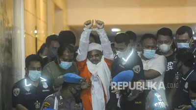 Imam Besar FPI Muhammad Rizieq Shihab memakai baju tahanan usai menjalani pemeriksaan di Mapolda Metro Jaya, Jakarta, Ahad (13/12). Rizieq resmi ditahan usai menjalani pemeriksaan sebagai tersangka kasus pelanggaran protokol kesehatan terkait kasus kerumunan yang terjadi di Petamburan. Republika/Putra M. Akbar (FOTO : Republika/Putra M. Akbar)