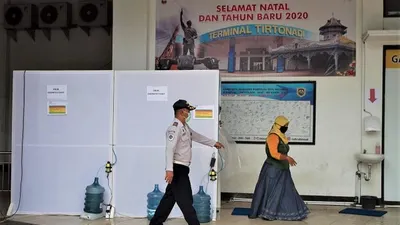 Petugas Terminal Tipe A (TTA) Tirtonadi Solo mengawasi penumpang yang masuk ke bilik disinfektan untuk mencegah paparan Covid-19. (Ayojakarta/Budi Cahyono)