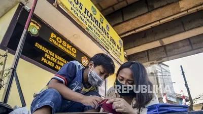 sebagai ilustrasi. Seorang siswa saat belajar didampingi orang tuanya di kolong rel kereta api Mangga Besar, Jakarta, Rabu (26/8/2020). Para siswa memilih belajar di kolong rel karena terdapat modem paket internet wifi gratis yang disediakan untuk membantu mengikuti pembelajaran jarak jauh. Republika/Putra M. Akbar (FOTO : Republika/Putra M. Akbar)