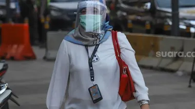 Seorang pekerja kantor menggunakan face shield dan masker saat melintas di Kawasan Sudirman, Jakarta Pusat, Senin (8/6). [Suara.com/Alfian Winanto]