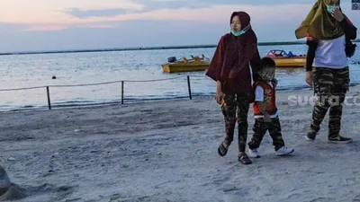 Pengunjung berwisata bersama keluarga di Pantai Karnaval Ancol, Jakarta Utara, Sabtu (20/6). [Suara.com/Alfian Winanto]