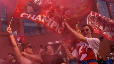 Di tengah pandemi COVID-19, sekelompok fans Liverpool melakukan perayaan di luar Stadion Anfield, Liverpool, Jumat (26/6/2020) dini hari WIB. Liverpool dipastikan menjuarai Liga Inggris 2019/2020 usai kekalahan 1-2 Manchester City di markas Chelsea. [OLI SCARFF / AFP]