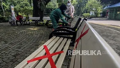 Petugas memasang tanda jarak di bangku saat simulasi persiapan pembukaan kembali Taman Margasatwa Ragunan, Jakarta Selatan, Kamis (11/6/2020). Ragunan dibuka kembali untuk umum pada Sabtu (20/6/2020). (Foto: Republika/Putra M. Akbar)