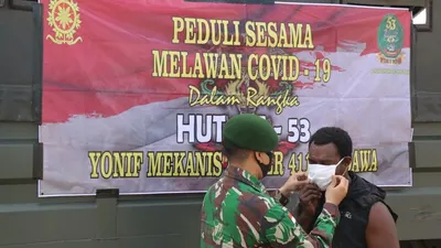 Prajurit memasangkan masker pada pekerja di Pelabuhan Merauke (Pasi Intel Satgas Yonif Mekanis Raider411/Pdw Kostrad, Lettu Inf Asep Saepudin)
