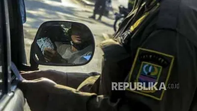 Petugas Satpol PP saat memeriksa dokumen pengendara yang akan memasuki wilayah DKI Jakarta di perbatasan Bekasi-Karawang, Jawa Barat, Jumat (29/5). Penyekatan kendaraan pemudik itu untuk mencegah kembalinya pemudik yang akan kembali ke Jakarta tanpa membawa Surat Izin Keluar Masuk (SIKM) guna mengatasi penyebaran virus Corona  (Foto: Republika/Putra M. Akbar)