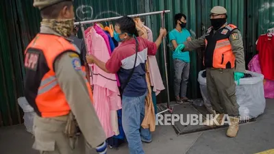 Petugas Satuan Polisi Pamong Praja (Satpol PP) menertibkan sejumlah pedagang pakaian di kawasan Tanah Abang, Jakarta, Ahad (17/5/2020). Penertiban tersebut dilakukan guna mengantisipasi sejumlah pedagang yang tetap berjualan menjelang Hari Raya Idul Fitri meski ada aturan penerapan sosial berskala besar (PSBB) guna mengantisipasi penyebaran pandemi Covid-19. Foto: Republika/Thoudy Badai
