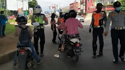 Sebagai ilustrasi, petugas memeriksa pengendara yang melintas di Bogor sebagai bentuk penertiban pelaksanaan PSBB. dok