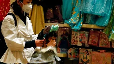 Seorang wanita dewasa dan seorang anak kecil memakai masker di sebuah toko suvenir di Hong Kong mengantisipasi penyebaran wabah virus Corona, 26 Januari 2020. (Bisnis.com/Reuters/Tyrone Siu)