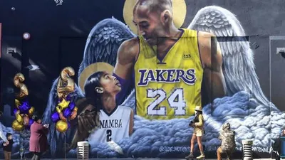 Sejumlah penggemar berkumpul di dekat sebuah mural dari mendiang pemain bola basket profesional NBA Kobe Bryant dan mendiang putrinya Gianna di pusat Kota Los Angeles, California, Amerika Serikat, Selasa (26/1/2021). [Frederic J. BROWN / AFP]