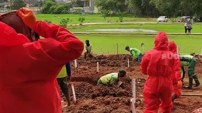 Petugas menggali makam untuk jenazah pasien Covid-19 di TPU Bambu Apus, Jakarta Timur. (Suara.com/Bagaskara)