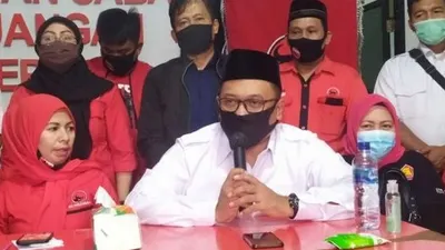 Calon wali kota Depok Pradi Supriatna (pegang mik) didamping calon wakil wali kota Afifah Alia (kiri) saat menjelaskan turunnya rekomendasi pencalonan mereka di kantor DPC PDI Perjuangan Depok, Jumat 17 Juli 2020/suara.com /Supriyadi