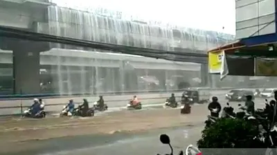 Pemandangan langka ketika para pengendara  melintas di bawah air terjun yang berasal dari badan Jalan Tol Becakayu, di kawasan Pondok Kelapa, Jakarta Timur yang berbatasan dengan Kota Bekasi, Jawa Barat, Kamis (21/11/2019). (Antara/Andi Firdaus)