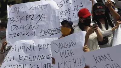 Sejumlah massa yang tergabung dalam Asosiasi Pengusaha Hiburan Jakarta (Asphija) membentangkan poster saat melakukan aksi unjuk rasa di depan Balai Kota DKI Jakarta, Selasa (21/7/2020). [Suara.com/Angga Budhiyanto]