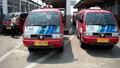Warga melintas di antara mobil-mobil angkutan kota (Angkot) di Terminal Bus Terpadu Pulogebang, Jakarta Timur, Jumat (2/8/2019). Melalui Instruksi Gubernur DKI Jakarta Nomor 66 Tahun 2019 tentang Pengendalian Kualitas Udara, Gubernur Anies Baswedan melarang angkutan umum berusia di atas sepuluh tahun dan yang tidak lulus uji emisi beroperasi di jalanan Ibukota pada 2020, serta akan mengebut peremajaan 10.047 unit angkutan melalui program Jak Lingko pada 2019 ini. (ANTARA FOTO/Aditya Pradana Putra)