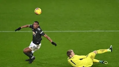 Penyerang Manchester United Anthony Martial (kiri) menaklukan kiper Aaron Ramsdale sebelum merobek gawang Sheffiled United dalam laga pekan ke-13 Liga Inggris di stadion Bramall Lane, Jumat (18/12/2020) dini hari WIB. [Laurence Griffiths / POOL / AFP]