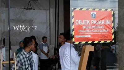 Stiker penunggak pajak ditempel Badan Pajak dan Retribusi Daerah (BPRD) DKI Jakarta di pintu lobi Apartemen Vittoria Residence. (Tribunjakarta.com/Elga Hikari Putra)