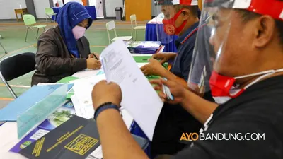 [ilustrasi] Orang tua mendaftarkan ulang anaknya dengan menyerahkan berkas kepada petugas melalui sistem luar jaringan (luring) pada Penerimaan Peserta Didik Baru (PPDB) di SMAN 8 Bandung, Jalan Solontongan, Kota Bandung, Selasa (23/6/2020). (Ayobandung.com/Irfan Al-Faritsi)