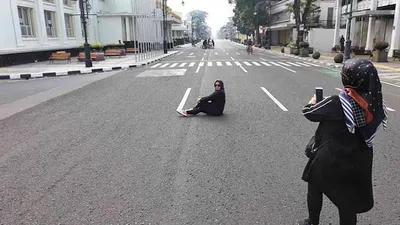 Sejumlah warga beraktivitas di Jalan Asia-Afrika yang ditutup untuk pembatasan sosial dan pengurangan titik kumpul warga guna mencegah penyebaran Covid-19 di Kota Bandung, Kamis (16/4/2020). (Ayobandung.com/Irfan Al-Faritsi)