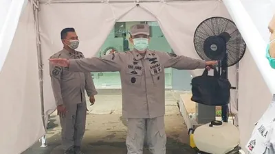 Setiap tamu maupun personel Bakamla RI yang akan memasuki kantor, termasuk Kepala Bakamla RI Laksdya TNI Aan Kurnia maupun pejabat utama Bakamla RI wajib mengikuti proses pemeriksaan suhu tubuh dengan thermometer infrared serta penyemprotan tubuh dengan cairan desinfektan.  (Humas Bakamla RI)