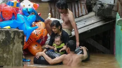 Warga dan anaknya korban banjir Jakarta sedang dievakuasi. (AFP/Bay Ismoyo)