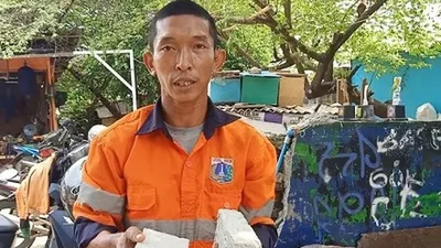 Petugas Tim Oranye UPK Badan Air Duren Sawit Toni Anthoni menunjukkan batako dari bahan baku sampah (Antara/Andi Firdaus)