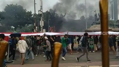 Bendara Merah Putih dibentangkan pendemo saat bentrok dengan aparat di kawasan Patung Kuda, dekat Istana Negara. (Suara.com/M Yasir).