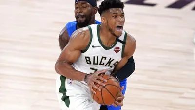 Bintang Milwaukee Bucks, Giannis Antetokounmpo, dipegangi oleh pemain Orlando Magic, Terrence Ross, dalam pertandingan play-off NBA, Minggu (30/8/2020) WIB. Foto: AP Photo/Ashley Landis