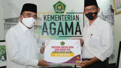 Menteri Agama Fachrul Razi menyerahkan BSU kepada guru dan tenaga kependidikan honorer atau non- PNS di lingkungan Kemenag seusai hari perayaan Hari Guru Nasional/kemenag.go.id