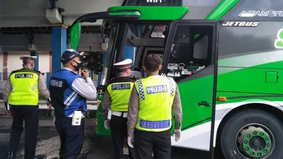 Petugas gabungan menghentikan bus saat hendak masuk ke Semarang di perbatasan di depan Terminal Mangkang, Senin (27/4/2020). (dok)