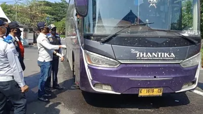 Petugas gabungan Pembatasan Kegiatan Masyarakat (PKM) menghentikan bus New Shantika saat hendak masuk ke Semarang di pos Mangkang, Jumat (1/5/2020). (dok).