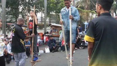 Sejumlah anak bermain permainan tradisional dengan ditemani sejumlah mahasiswa dari 'Penggerak Olahraga' saat Car Free Day di kawasan Bunderan HI, Jakarta, Minggu (14/7/2019). Kegiatan rutin ini sebagai bentuk pengabdian untuk masyarakat untuk membuat masyarakat DKI Jakarta aktif berolahraga. ANTARA FOTO/Reno Esnir/ama.