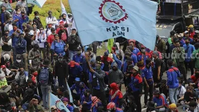 Massa aksi yang tergabung dalam elemen buruh mengibarkan bendera saat berunjuk rasa di kawasan Patung Kuda Arjuna Wiwaha, Jakarta, Kamis (22/10/2020). [Suara.com/Angga Budhiyanto]