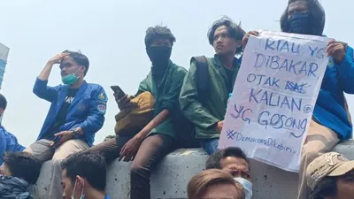 Seorang mahasiswa membawa poster yang isinya menyindir anggota DPR RI dalam demonstrasi besar-besaran pada Selasa lalu (24/9/2019)/Ayojakarta.com