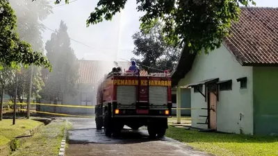 Petugas Damkar tengah menyemprot Pusdikpom dengan disinfektan. (ist)