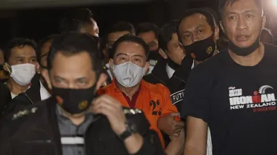 Petugas kepolisian membawa buronan kasus korupsi pengalihan hak tagih (cessie) Bank Bali Joko Soegiarto Tjandra alias Djoko Tjandra yang ditangkap di Malaysia setibanya di Bandara Halim Perdanakusuma, Jakarta, Kamis (30/7/2020). (Suara.com/Angga Budhiyanto)