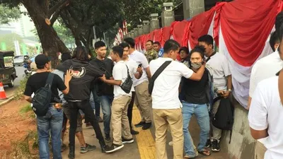 Polisi berkaos putih menggeledah paksa masa berkaos hitam yang diduga akan berdemo di depan gedung parlemen di Jakarta, Jumat (16/8/2019). (ANTARA/Galih Pradipta)